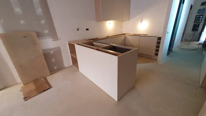 Cocina en U con isla blanca recién instalada
