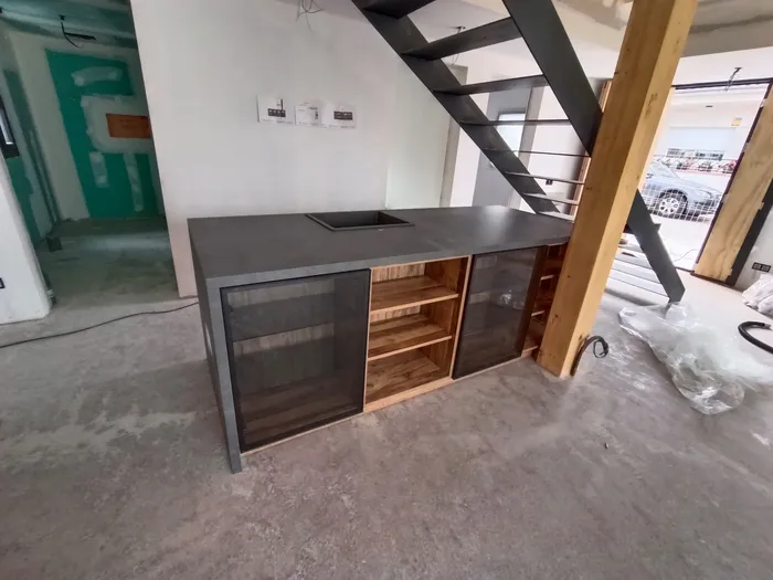 Isla de cocina con encimera de mármol gris y puertas de cristal